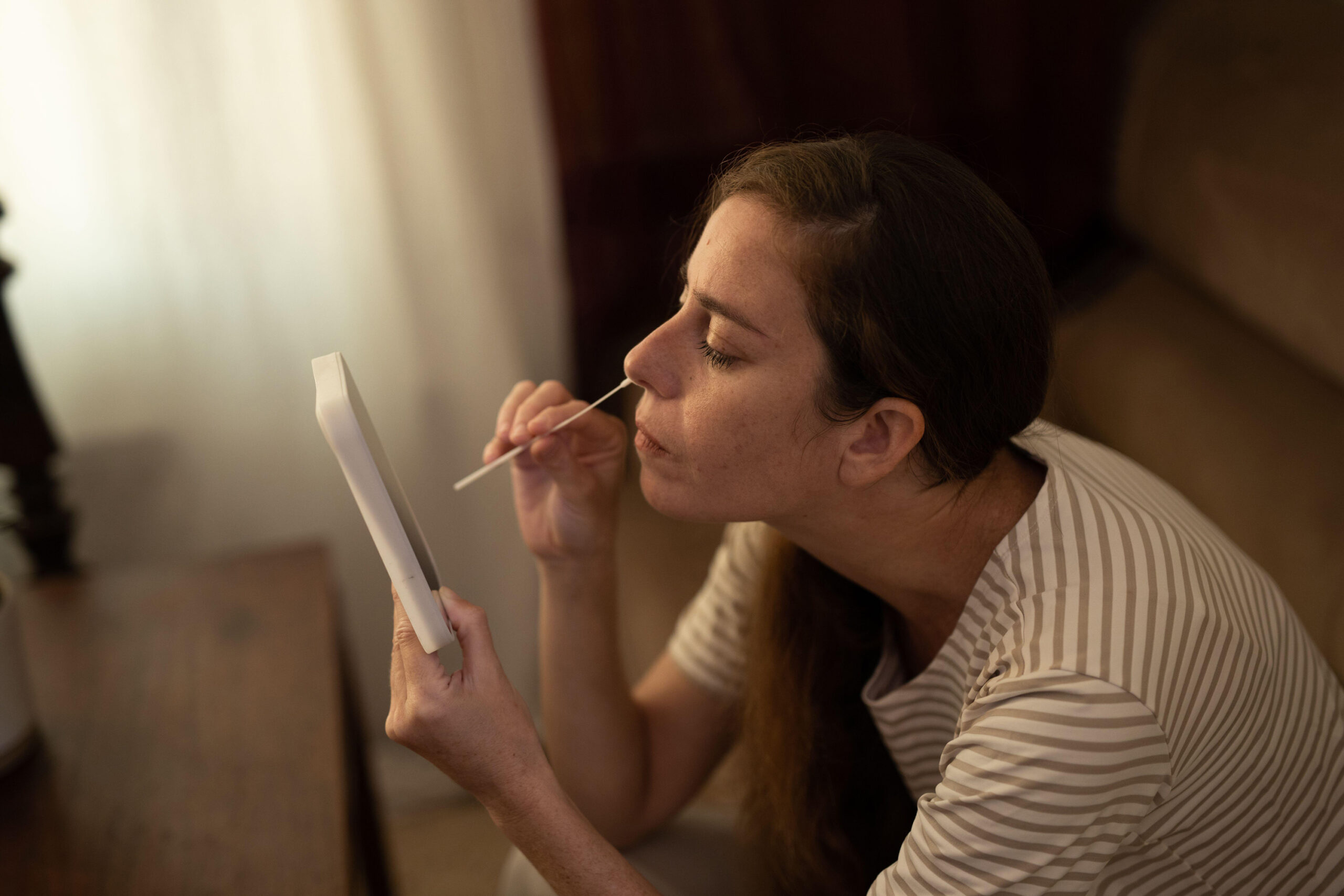 Woman performs a Covid 19 self test at home