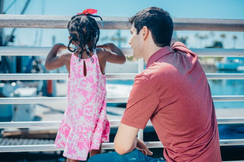 Man and young girl enjoying quality time together on a sunny day by the water
